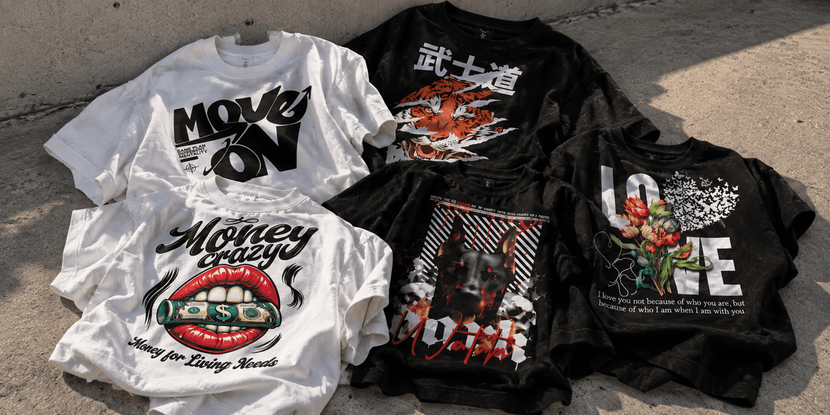 Five graphic t-shirts in white and black are laid out on a concrete surface. The shirts feature various streetwear-style designs, including the words 'MOVE ON', 'Money Crazy', 'LOVE', and Japanese characters, along with red lips, a dollar sign, and abstract graphics.